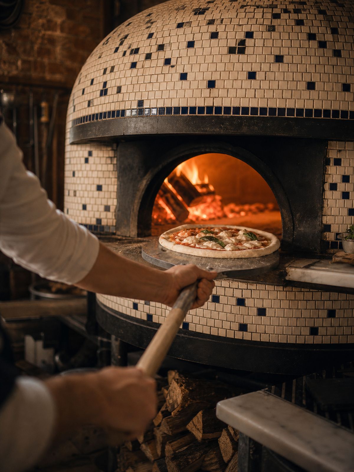 Pizzaiolo przy piecu opalanym drewnem